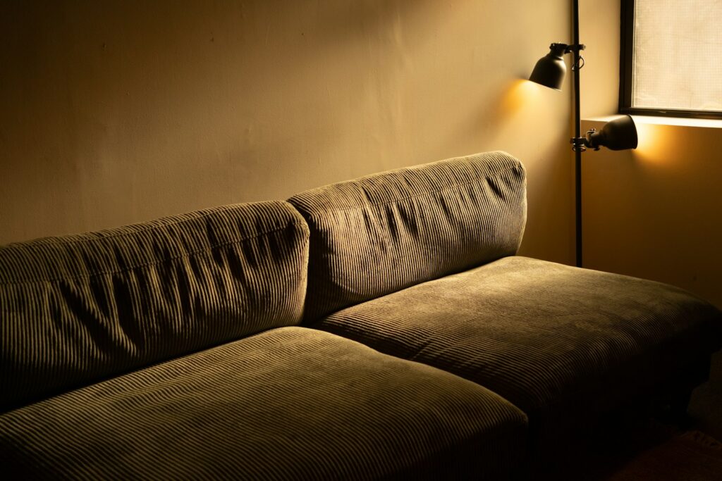 Gedimmtes Wohnzimmer mit Sofa und zwei Wandleuchten – Lichtszene mit Smart Home Licht