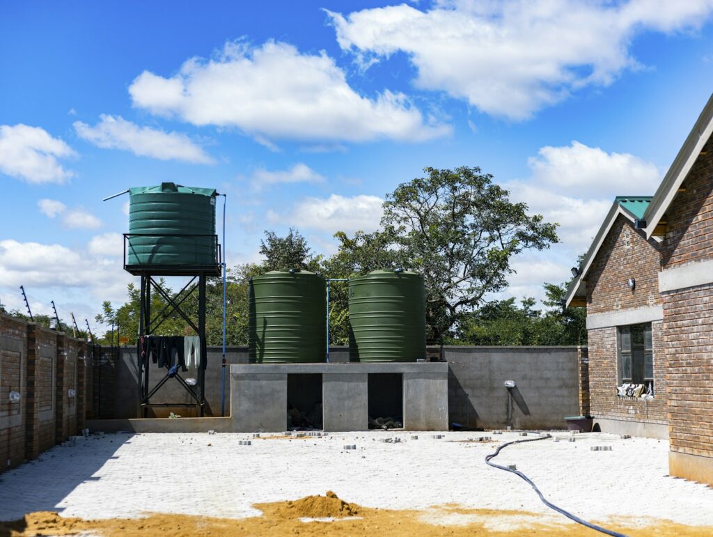 Grüne Wassertanks zum Regenwasser nutzen in einem Hof