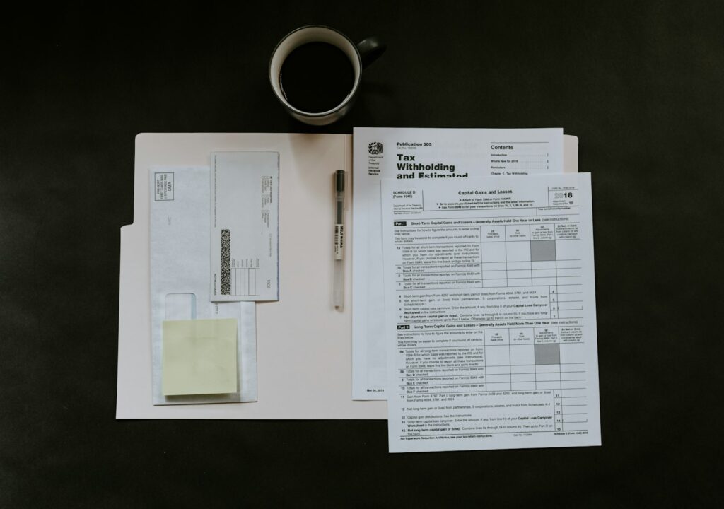 Steuerformulare, Stift und Kaffeetasse auf einem Schreibtisch – Unterlagen zur Grundsteuer prüfen