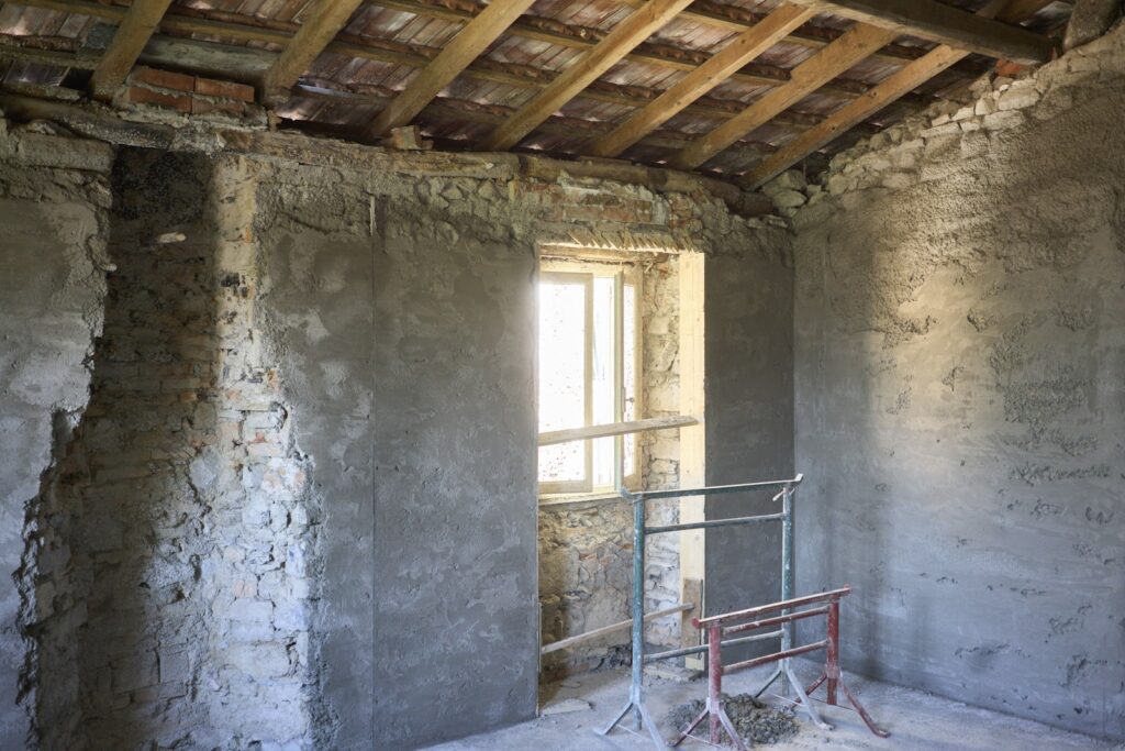 Altbau sanieren: leerer Raum mit Leiter vor einem Fenster während der Renovierung
