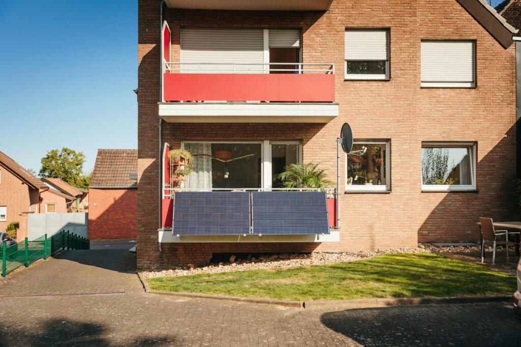 Balkon mit Solarmodulen an einem Backsteinhaus – Steckersolargerät korrekt registriert