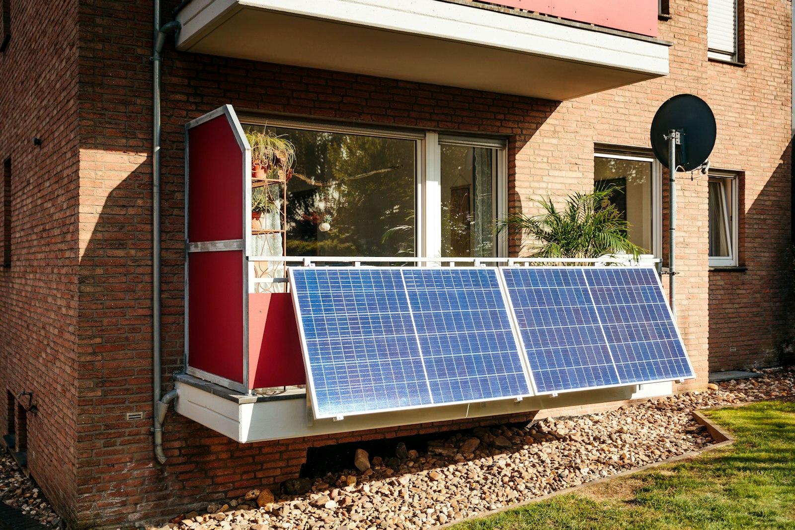 Balkonkraftwerk 2000 Watt: Solarmodule an einem Balkon aus Backstein