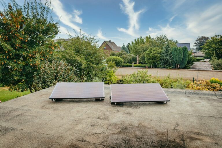 Balkonkraftwerk 800 Watt Ertrag: zwei Solarmodule auf einem Dach zwischen Bäumen