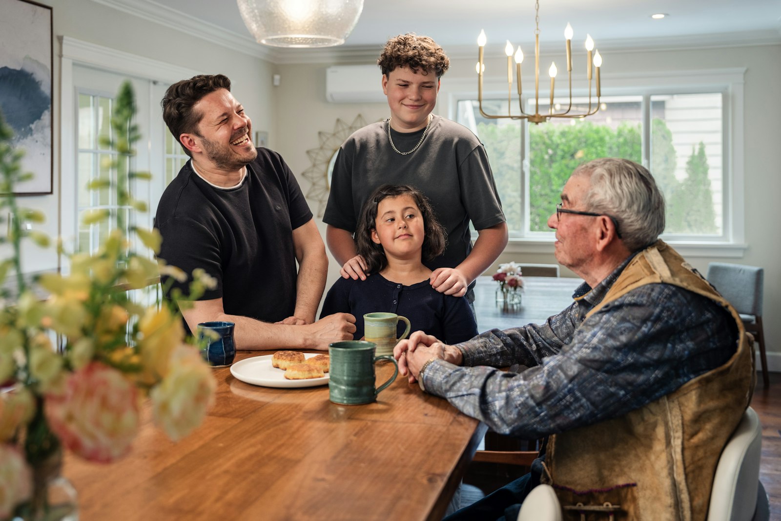 Erbengemeinschaft Haus Kosten: Familie sitzt gemeinsam am Holztisch