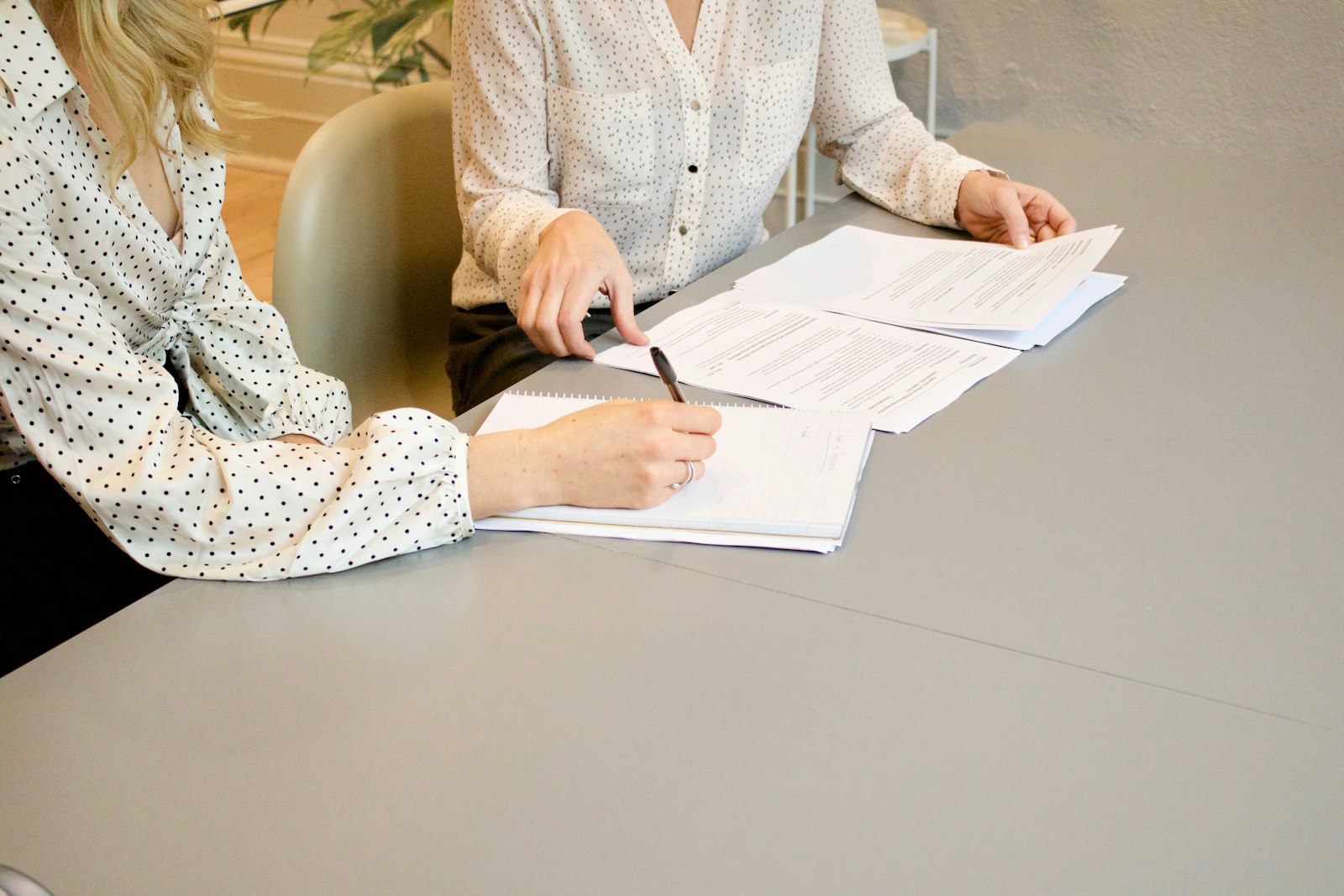 Grundbuch Abteilung 2: zwei Frauen prüfen und unterschreiben Dokumente am Tisch