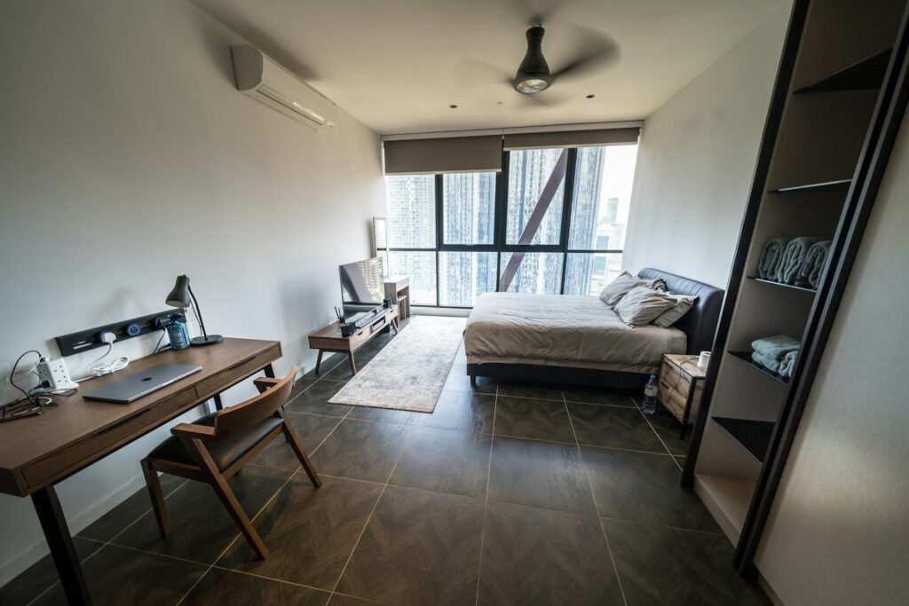 Homeoffice im Schlafzimmer: modernes Schlafzimmer mit Schreibtisch und Blick auf die Stadt