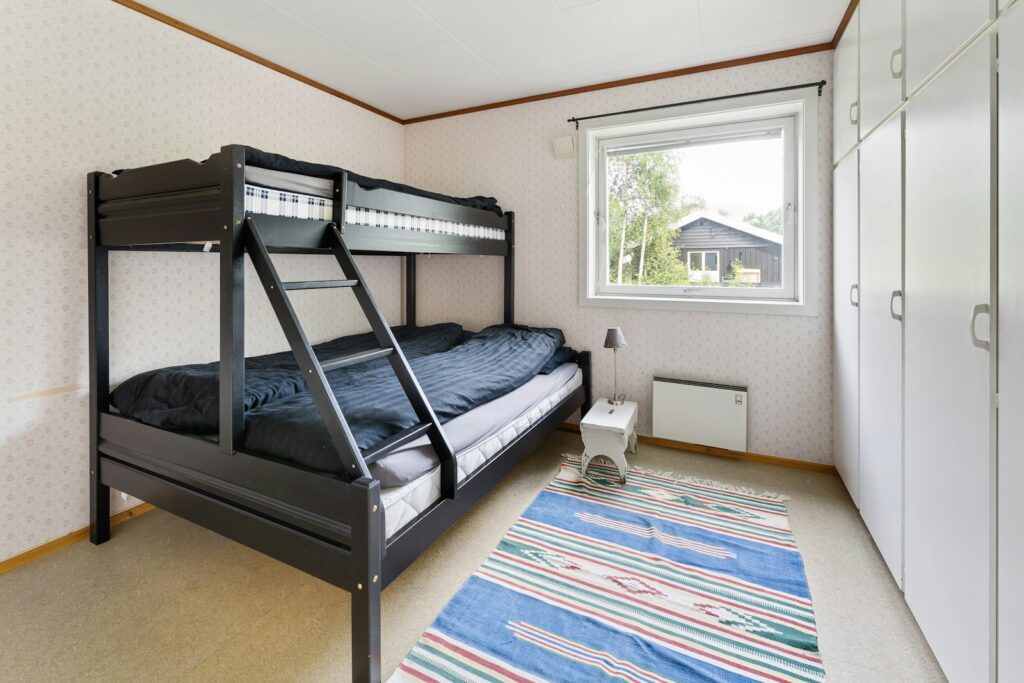 Kinderzimmer teilen mit Etagenbett, Teppich und Spielzeug auf dem Boden