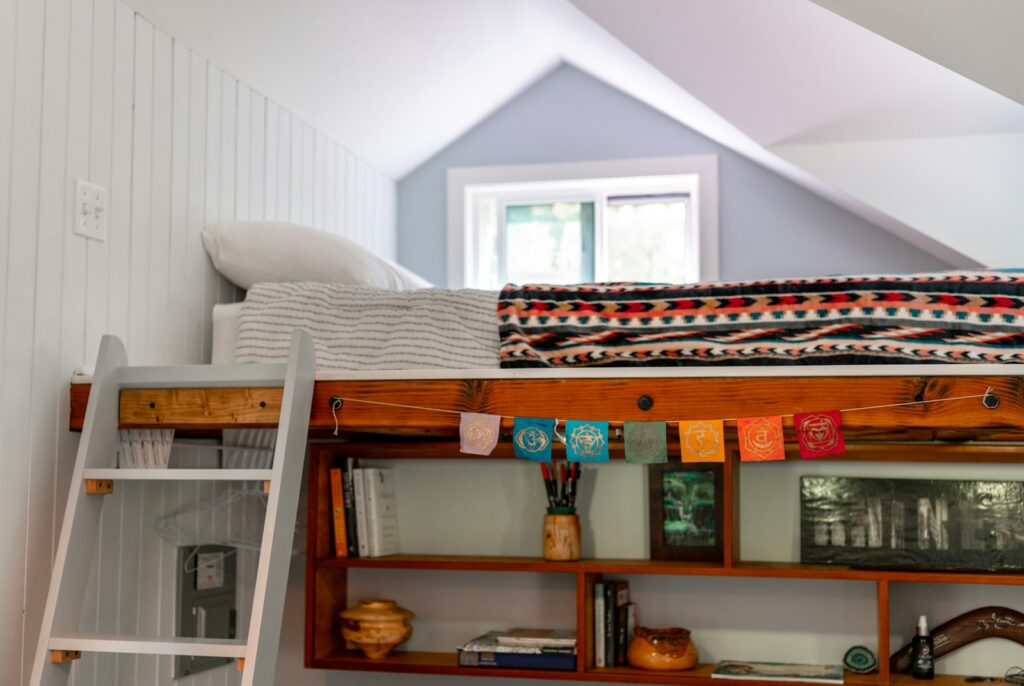 Kinderzimmer teilen mit Hochbett, Leiter und Regal für mehr Platz am Boden