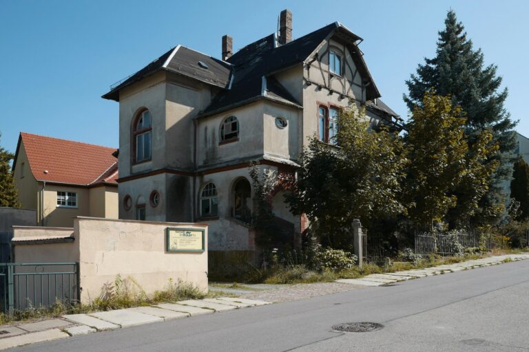 Sanierungspflicht erben: älteres Einfamilienhaus an einer Straße in Deutschland