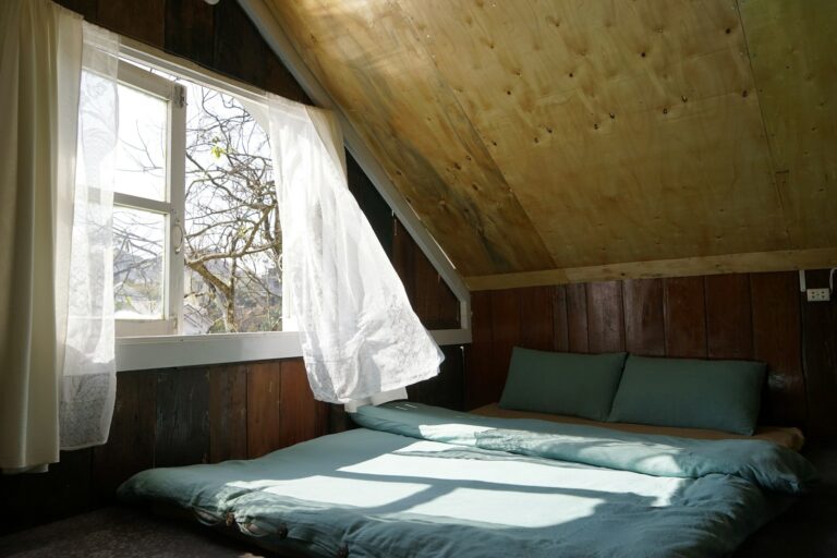 Schlafzimmer Dachschräge mit gemütlichem Bett und Fenster im Dachgeschoss