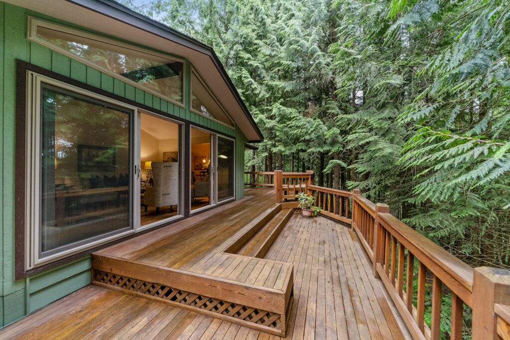 Terrasse aus Holzdielen vor einer Glastür – Terrasse Holz oder WPC im Vergleich