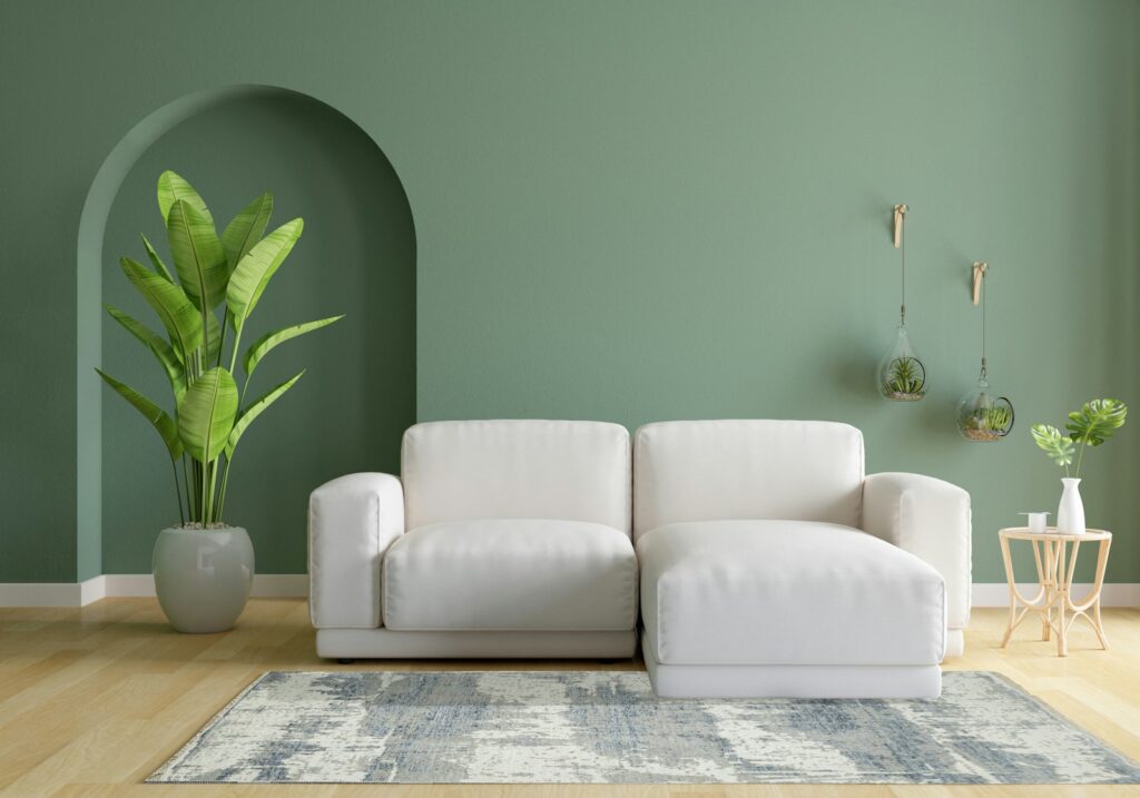 Trendfarben 2026 im Wohnzimmer mit grünen Wänden und weißem Sofa