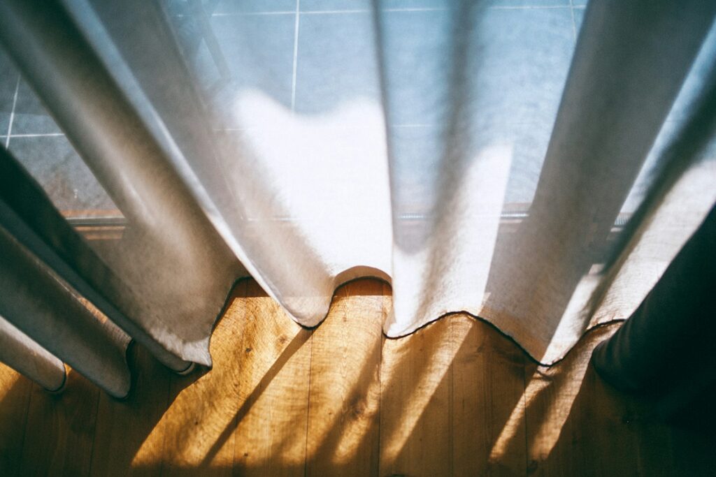 Vorhänge waschen: Nahaufnahme eines weißen Vorhangs am Fenster