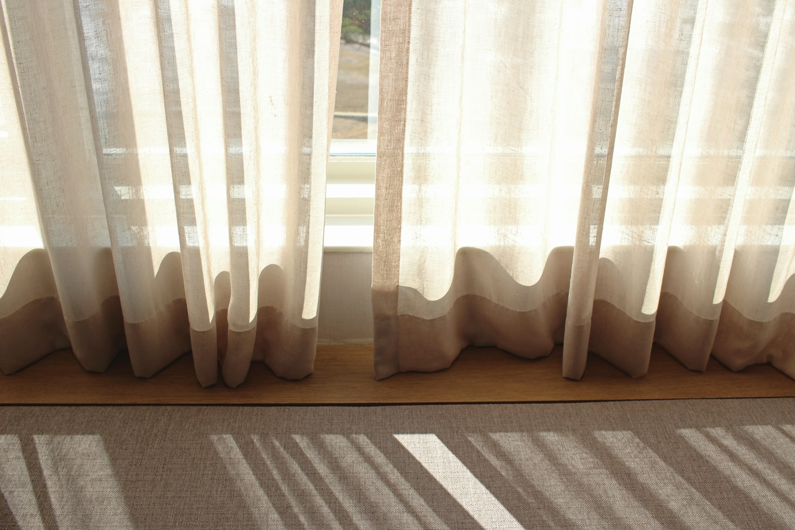 Vorhänge waschen: weißer Vorhang am Fenster bei Tageslicht