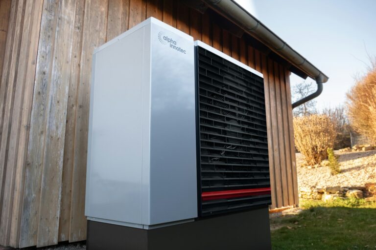 Wärmepumpe Kosten monatlich: Außengerät einer Wärmepumpe vor einem Gebäude