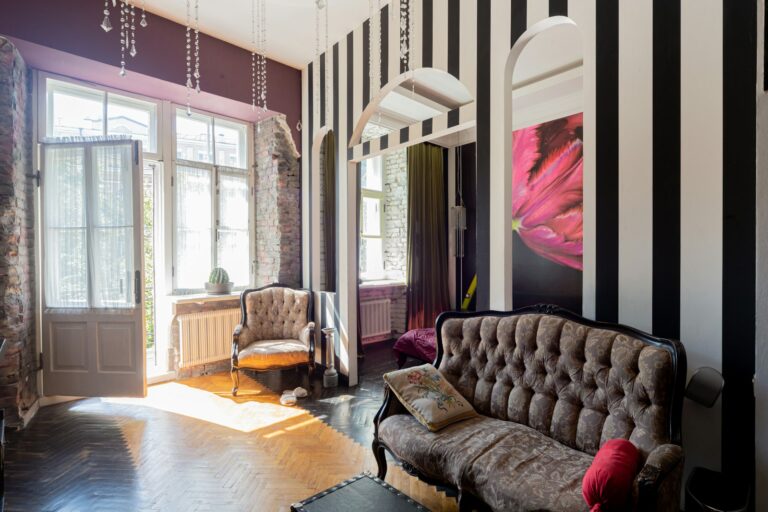 Wandgestaltung Streifen in einem Wohnzimmer mit gestreiften Wänden, Sofa und Möbeln