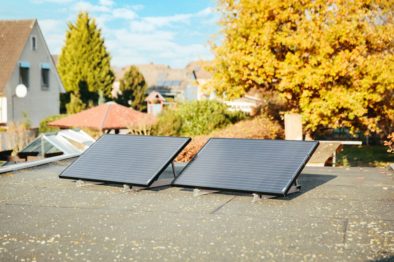 Was bringt ein Balkonkraftwerk: zwei Solarmodule vor herbstlichem Laub