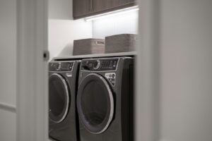 Waschmaschine reinigen: moderner Hauswirtschaftsraum mit Waschmaschine und Trockner