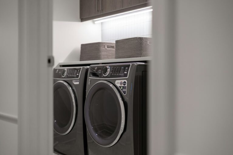 Waschmaschine reinigen: moderner Hauswirtschaftsraum mit Waschmaschine und Trockner